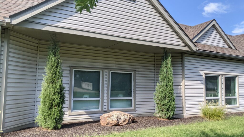 Some dumb landscaper planted trees with a 25-foot mature height directly under this overhang. Growth regulation can slow canopy expansion and help these trees last longer in a space they were never designed for.